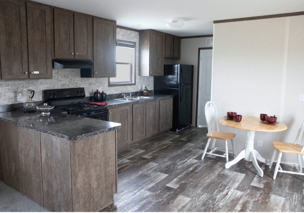A sample kitchen furnished with a laminate countertop and cupboards in a manufactured home
