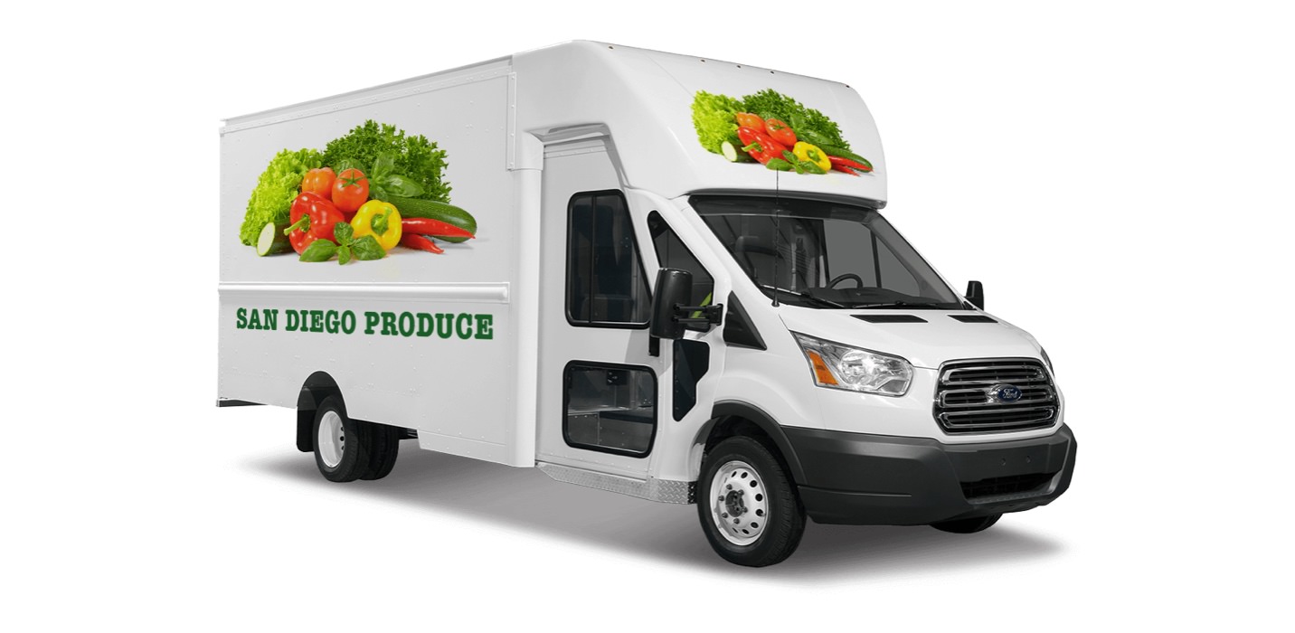 A delivery truck is decorated with images of vegetables and the words 
