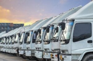 A fleet of trucks sit in a parking lot