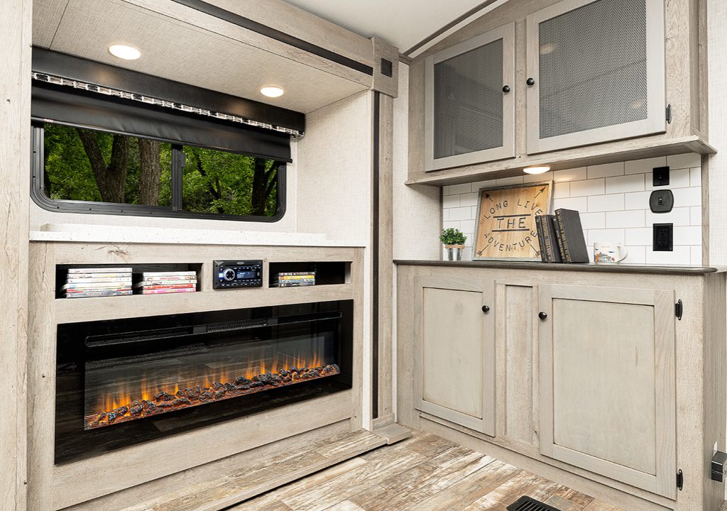 A livingroom in an RV has multi-toned doors on the cabinets
