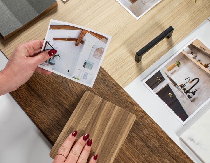 A woman is comparing a picture to wood samples in showroom